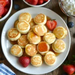 Golden mini pancakes with strawberries and blueberries.